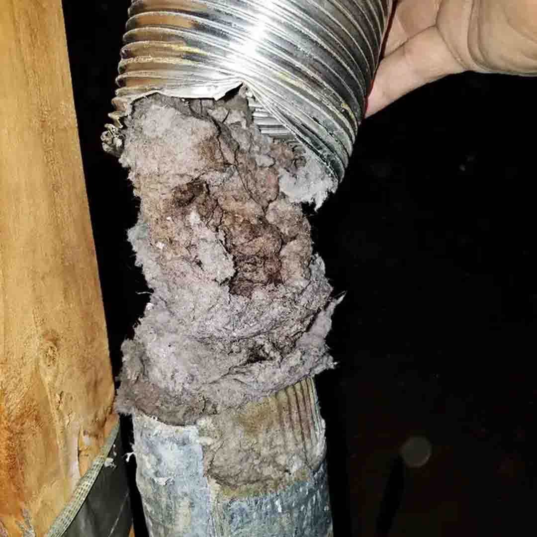 A silver metal dryer vent in disrepair.