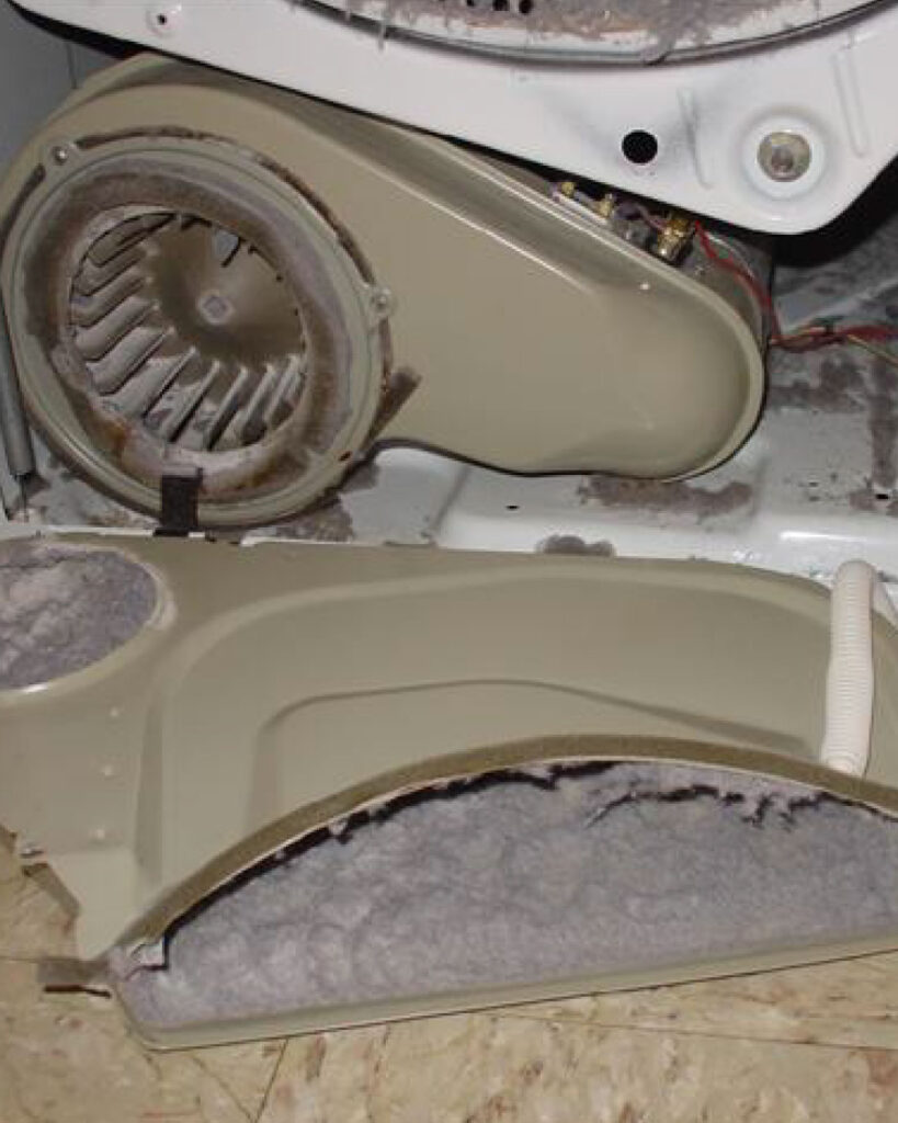 Lint lays on the ground after a technician has cleaned out the lint trap and interior of a dryer.