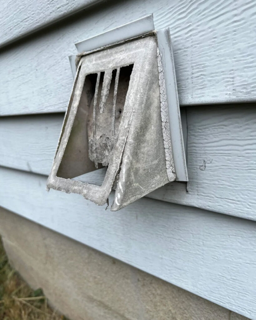 A medium shot of a dryer vent cover in disrepair.